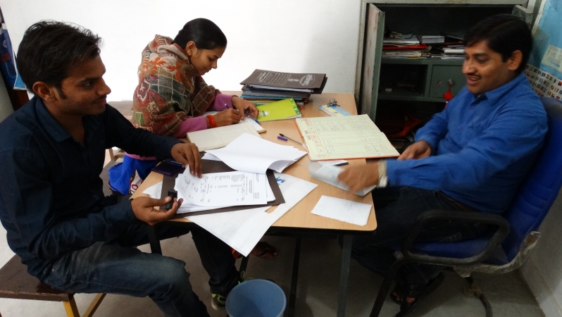 secretaris Vidhya en twee leerkrachten aan de administratie